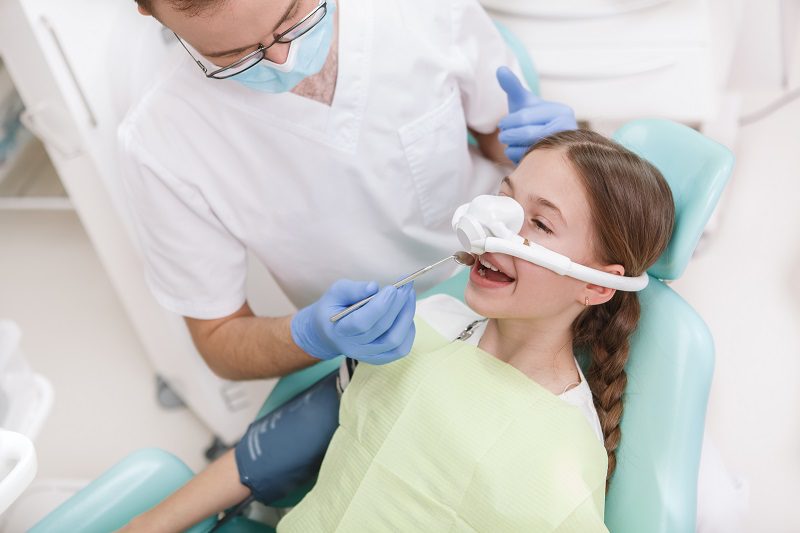 young-girl-having-her-teeth-treated-while-having-inhalation-sedation-mask.jpg